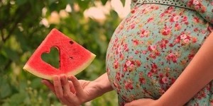 plasterek arbuza w dłoni kobiety w ciąży
